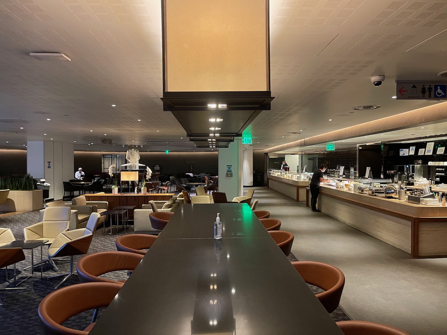 a long black table with chairs in a room with a counter