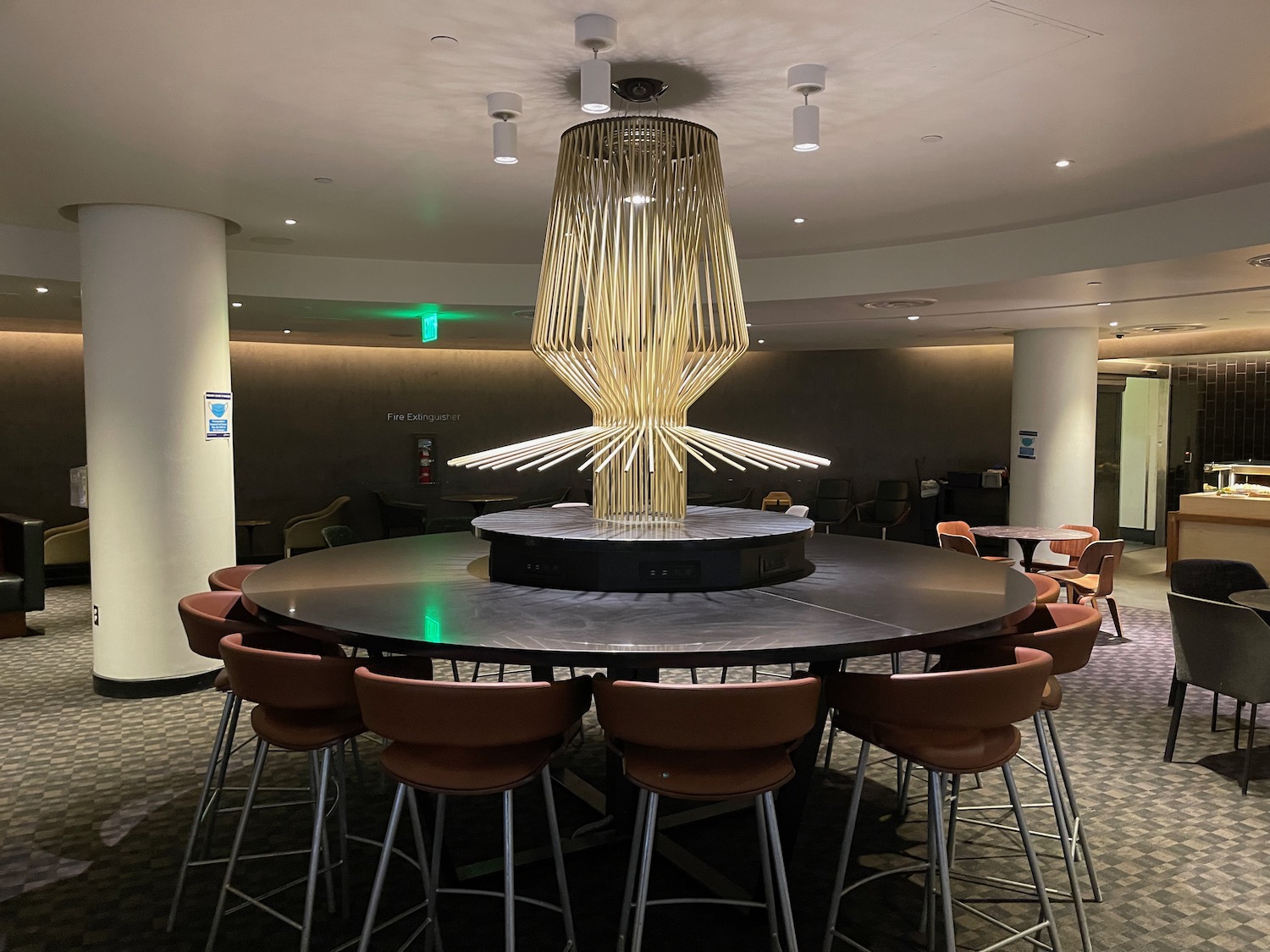 a large chandelier on a round table with chairs around it