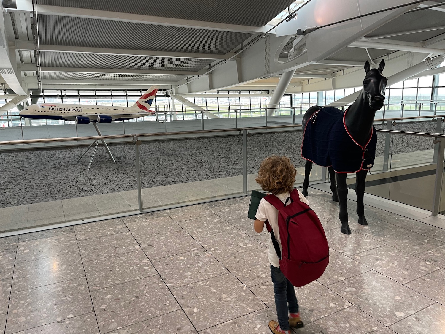 a child looking at a horse model in a building