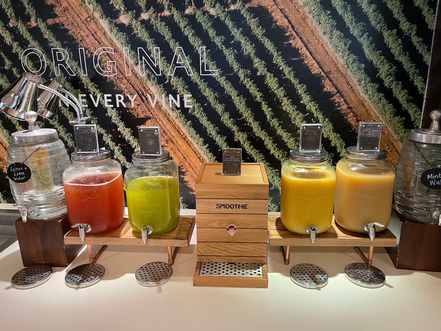 a row of juice dispensers on a table