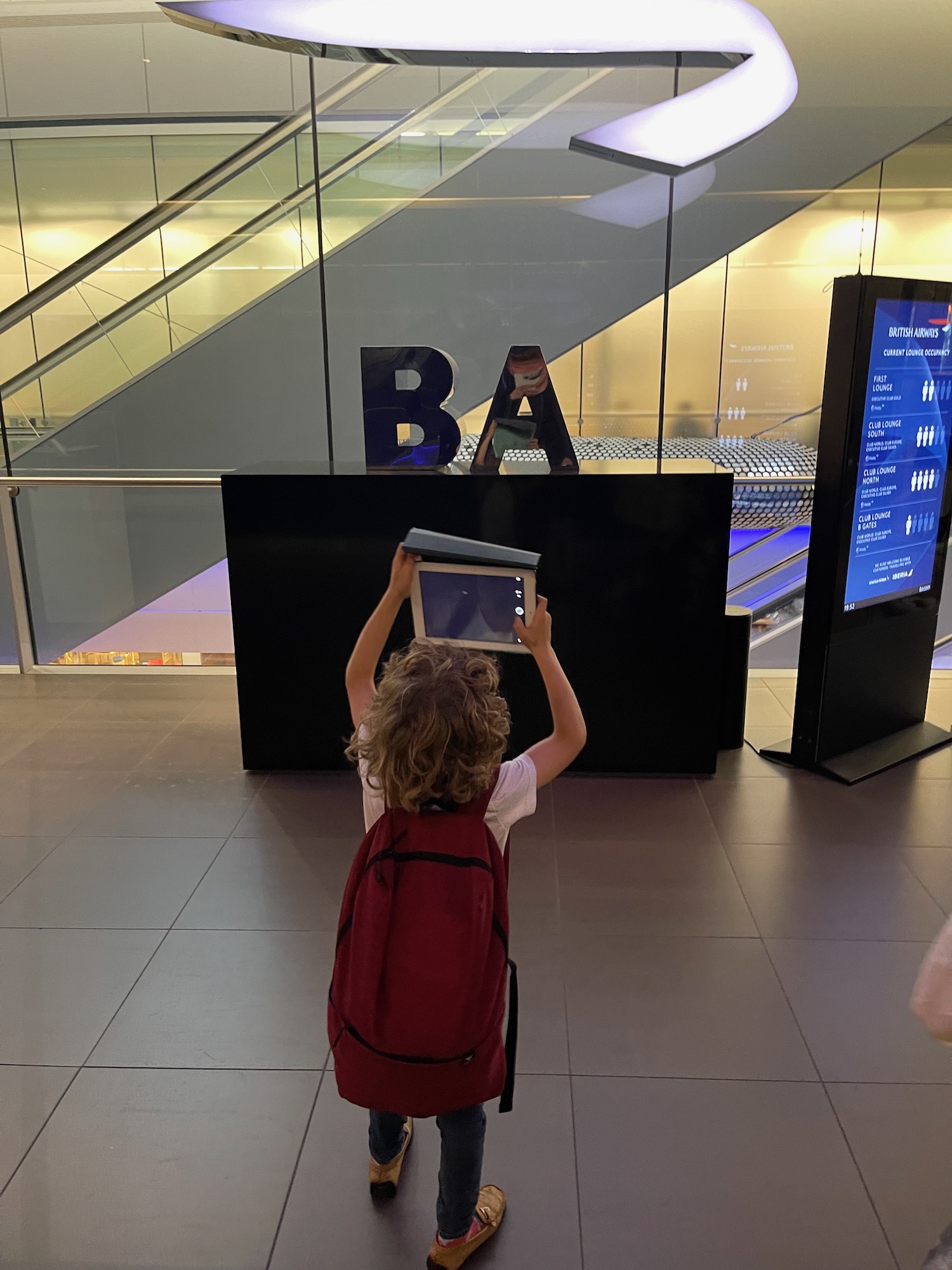 a child holding a tablet up to his head