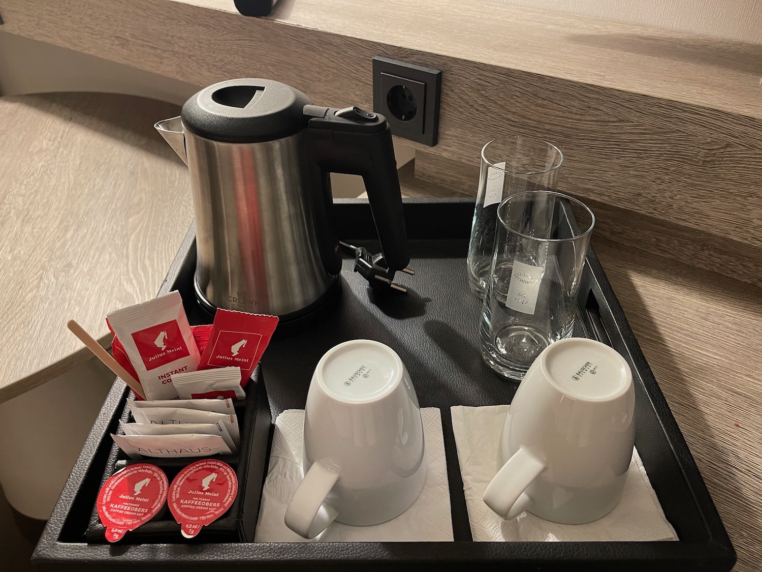 a tray with coffee pot and cups and sugar packets