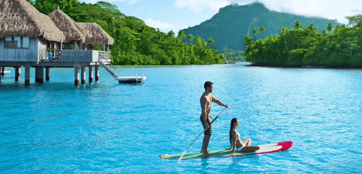 a man and woman on a paddle board in water