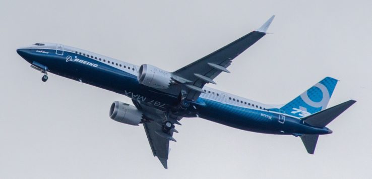 a blue and white airplane flying in the sky