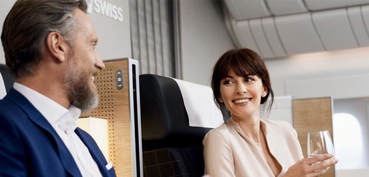 a woman and man sitting in an airplane