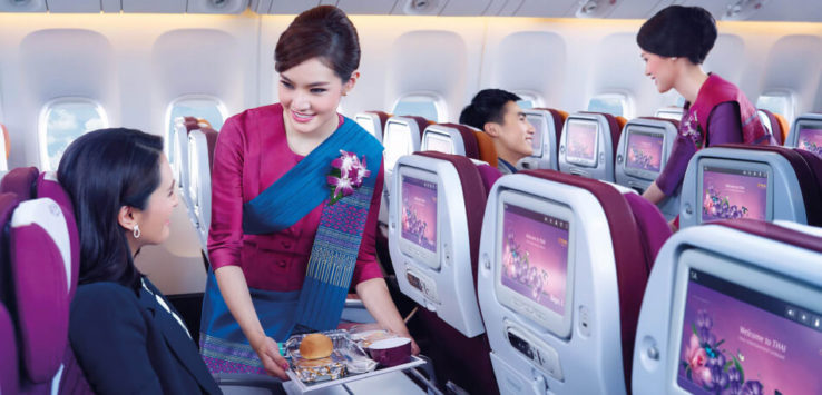 a woman serving food in an airplane