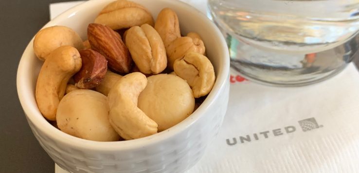 a bowl of nuts and a glass of water