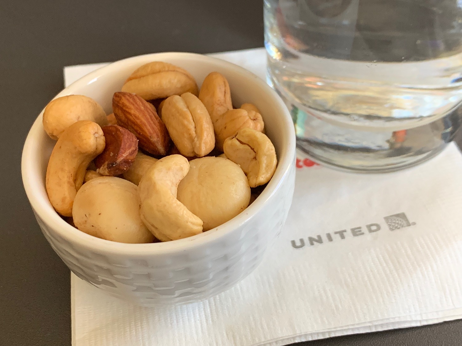 a bowl of nuts and a glass of water