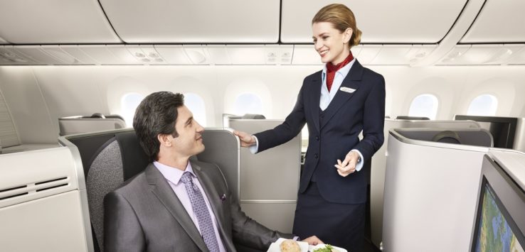 a woman in a suit standing next to a man in a plane