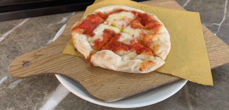 a small pizza on a wooden board