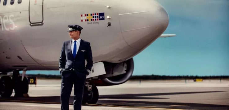 a man in a suit standing in front of a plane