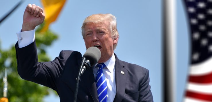 a man in a suit speaking into a microphone