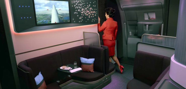a woman in a red suit standing in a cabin of an airplane