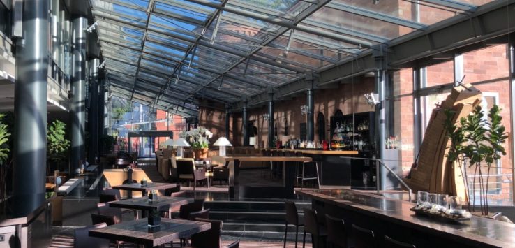 a glass roof with tables and chairs