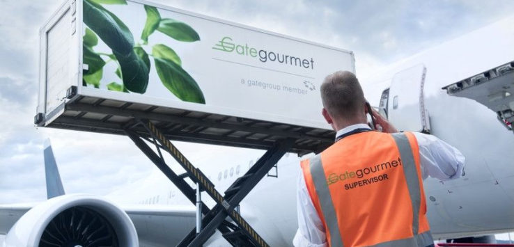 a man in an orange vest standing next to an airplane