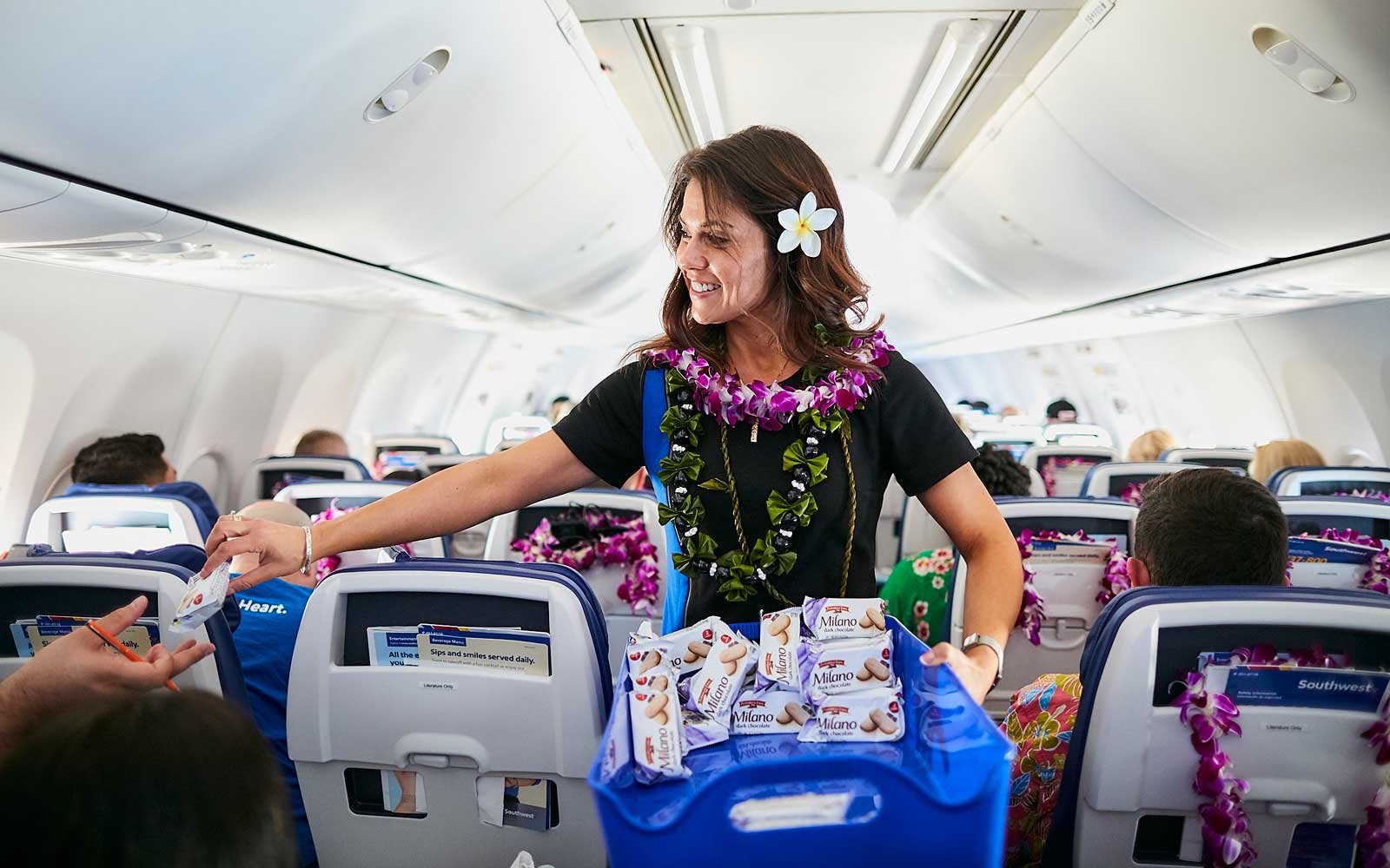 a woman in a lei standing in an airplane