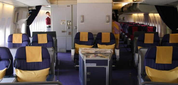 an inside of an airplane with blue and yellow seats