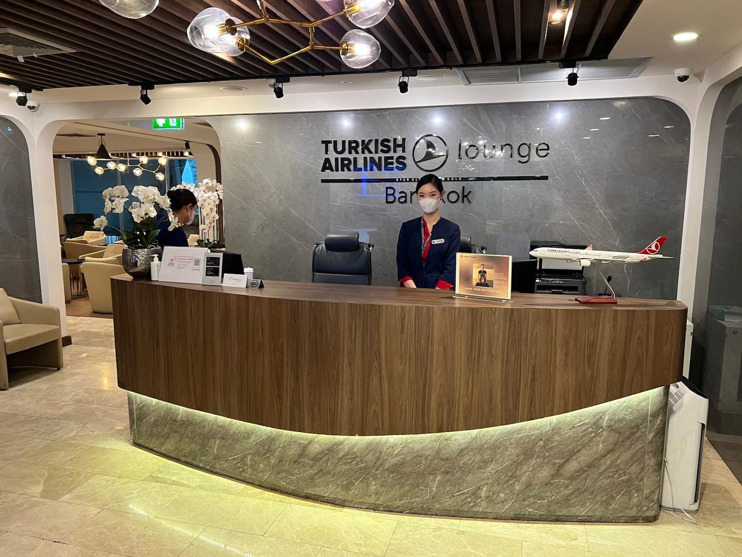 a woman standing at a desk in a hotel