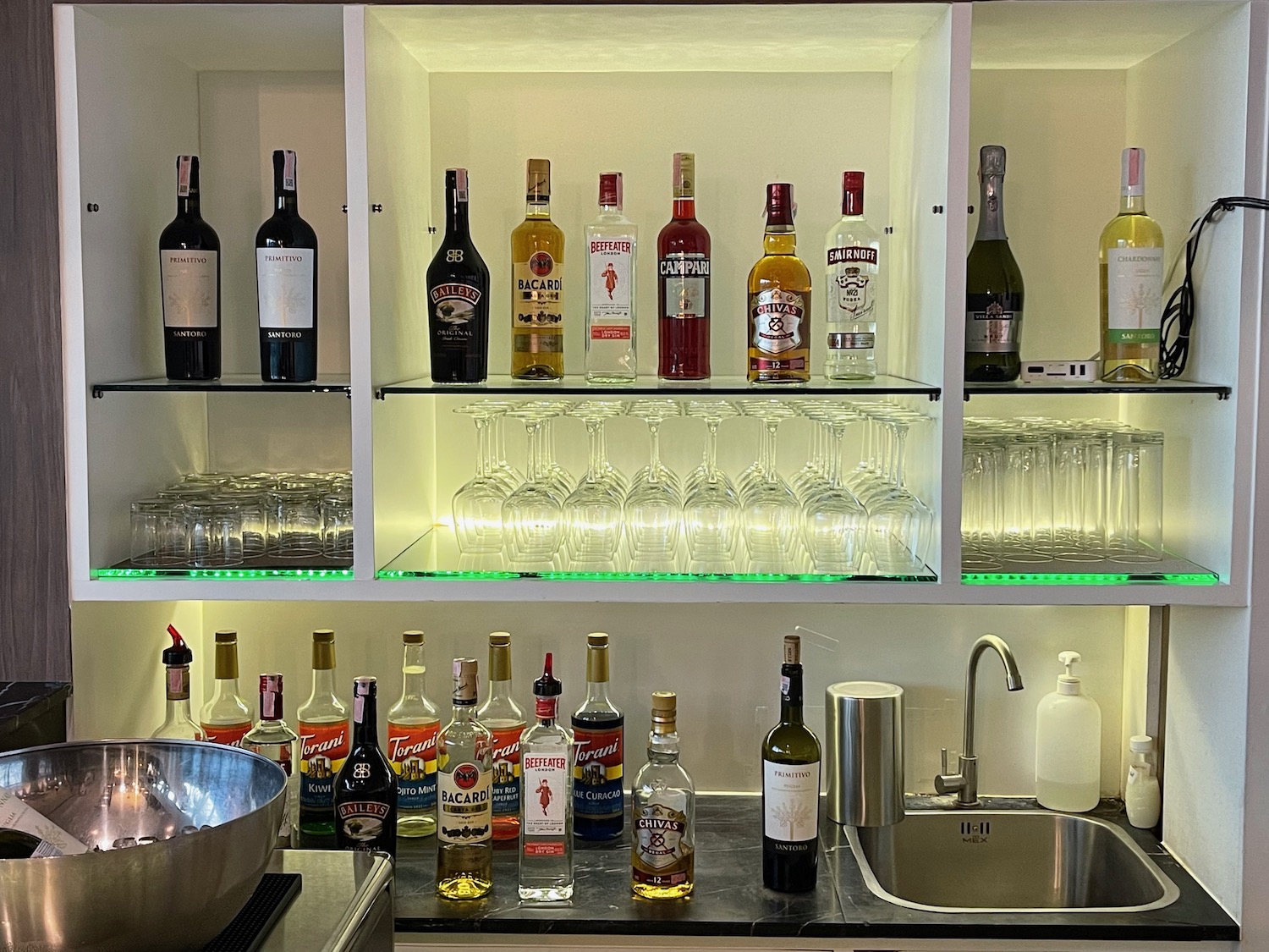 a shelf with bottles and glasses on it