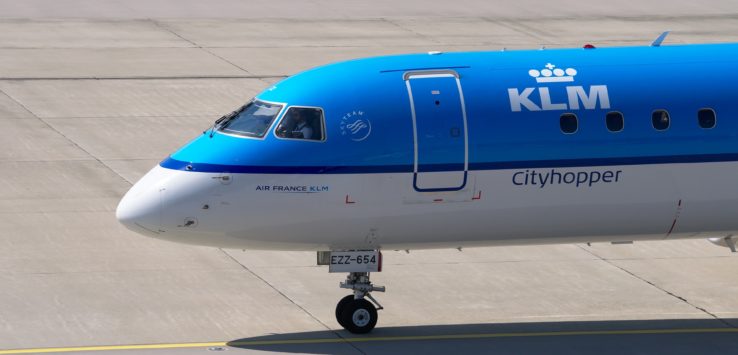 a blue and white airplane on a runway