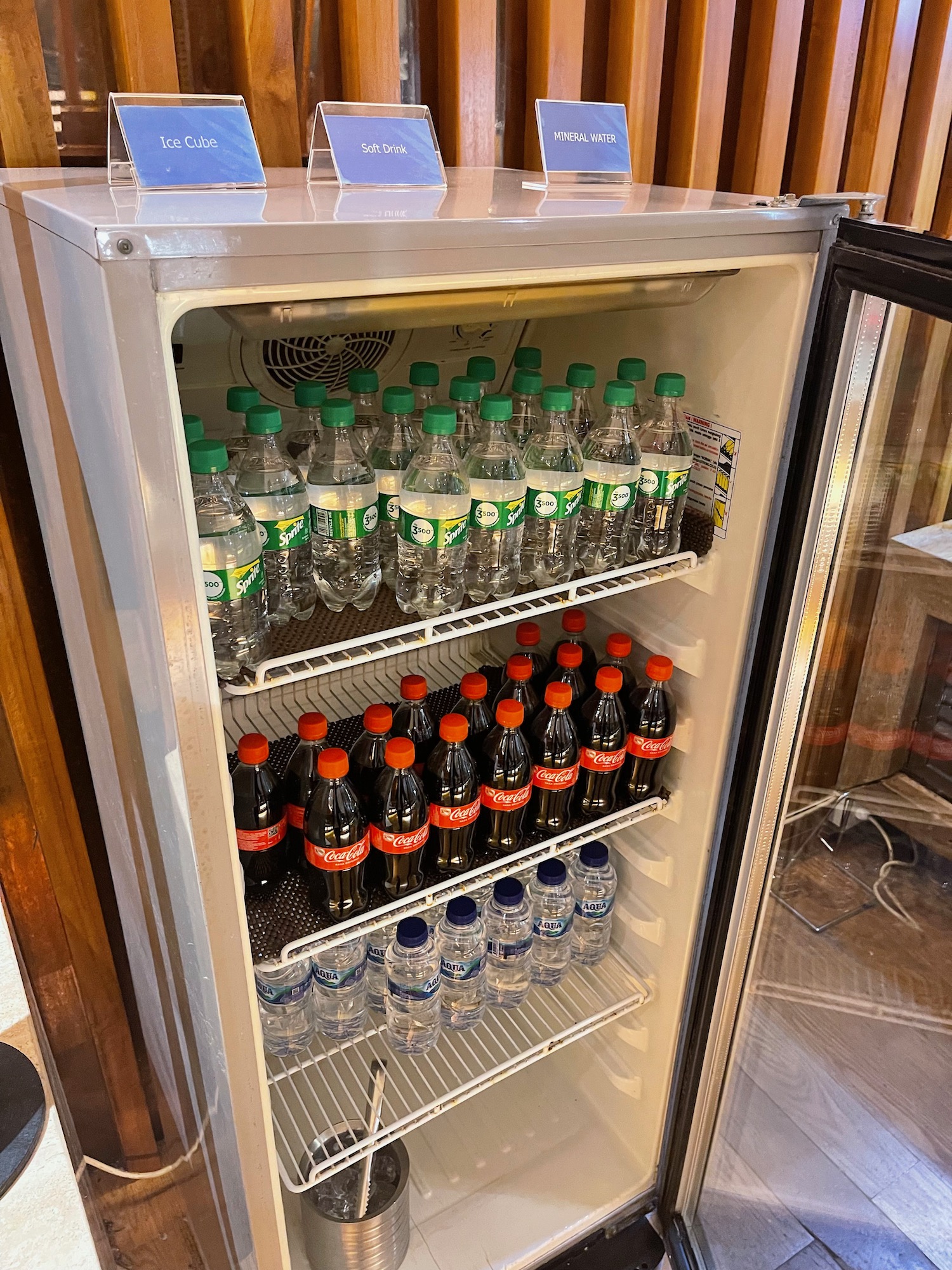 a refrigerator with bottles of soda and water