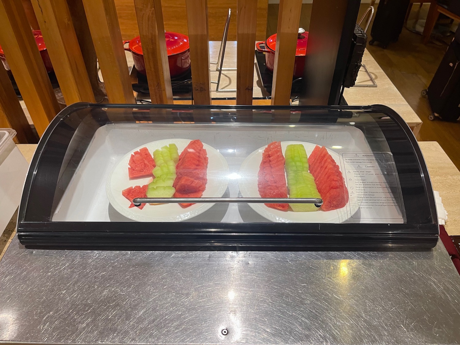 a plate of watermelon and melon in a glass case