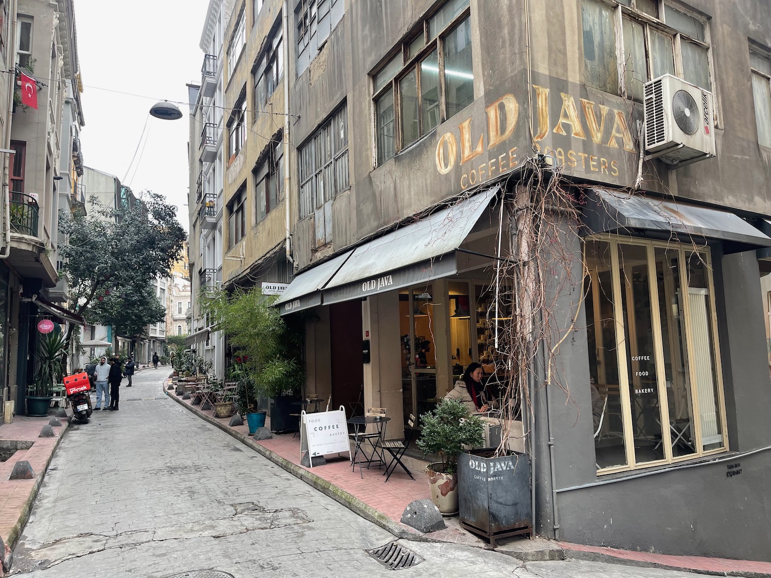 a street with a building and people walking around