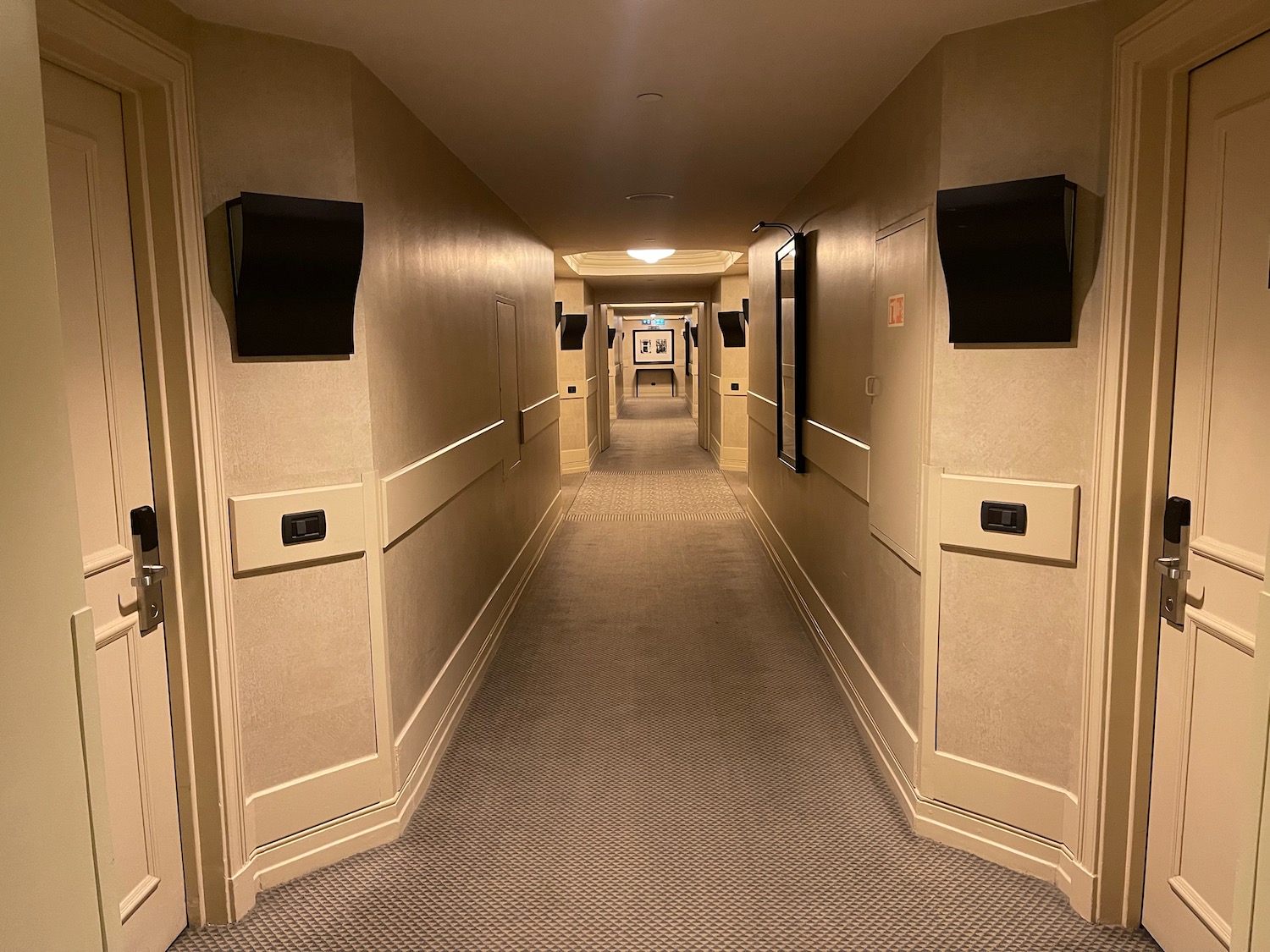 a hallway with black doors and a light on the wall