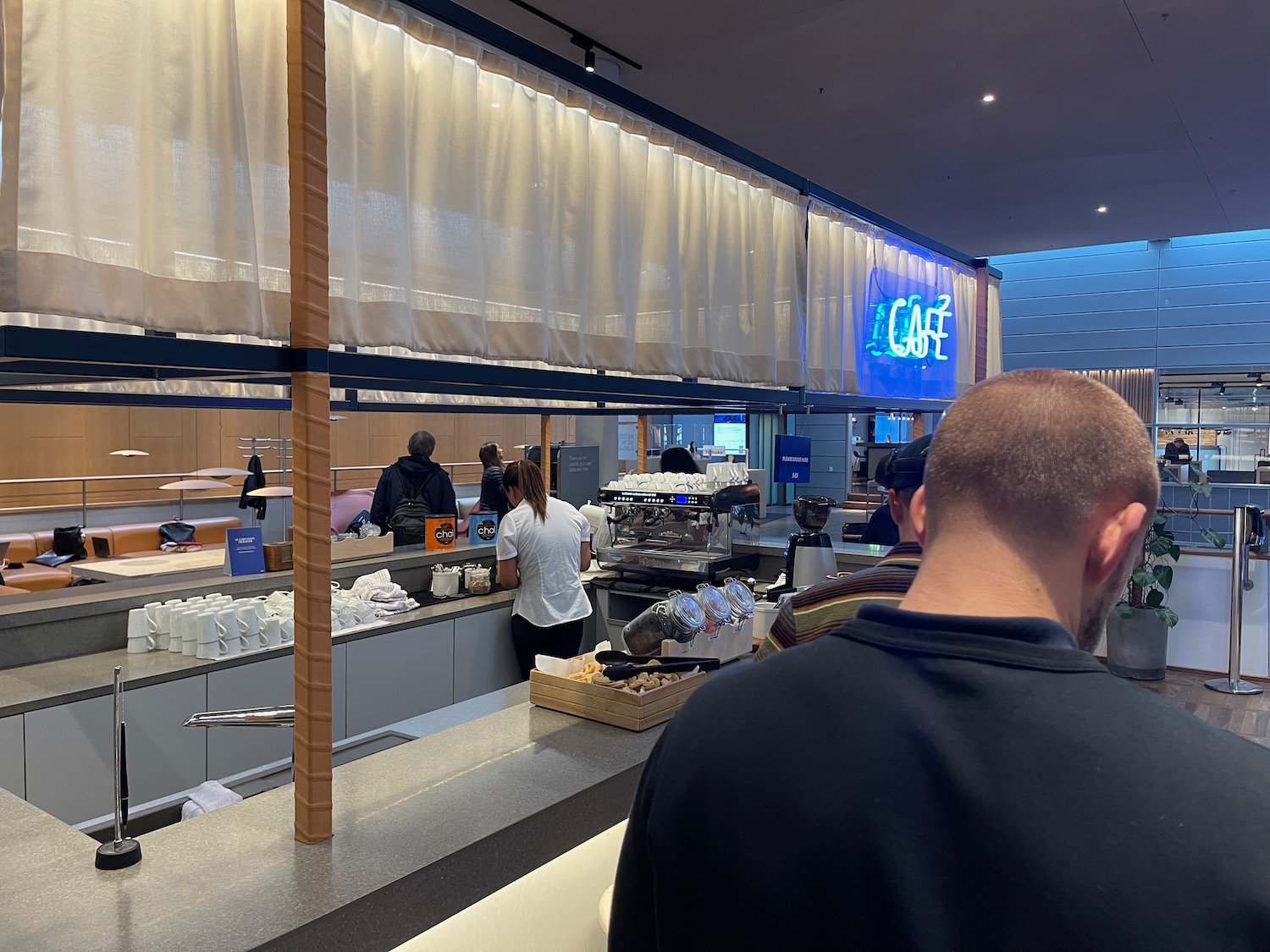 people standing in a line at a cafe