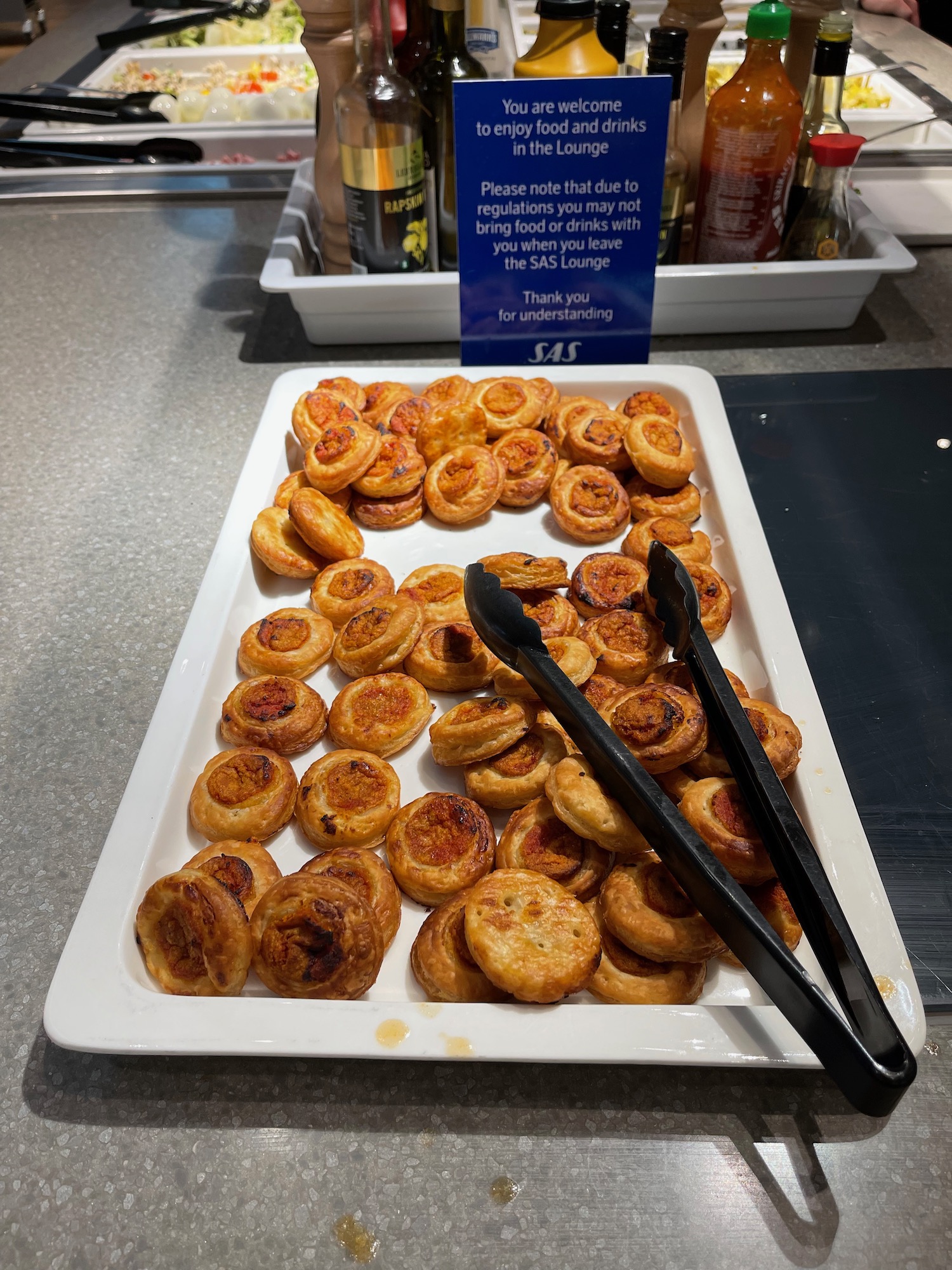 a tray of pastries and tongs