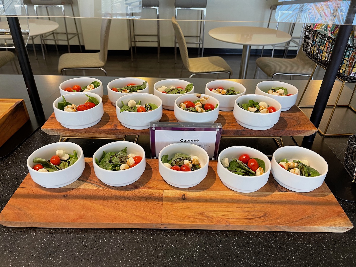 a group of white bowls of salad on a wooden table