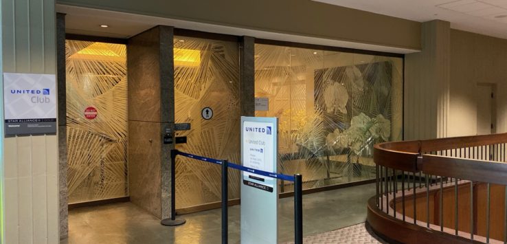 a glass wall with a railing and a sign