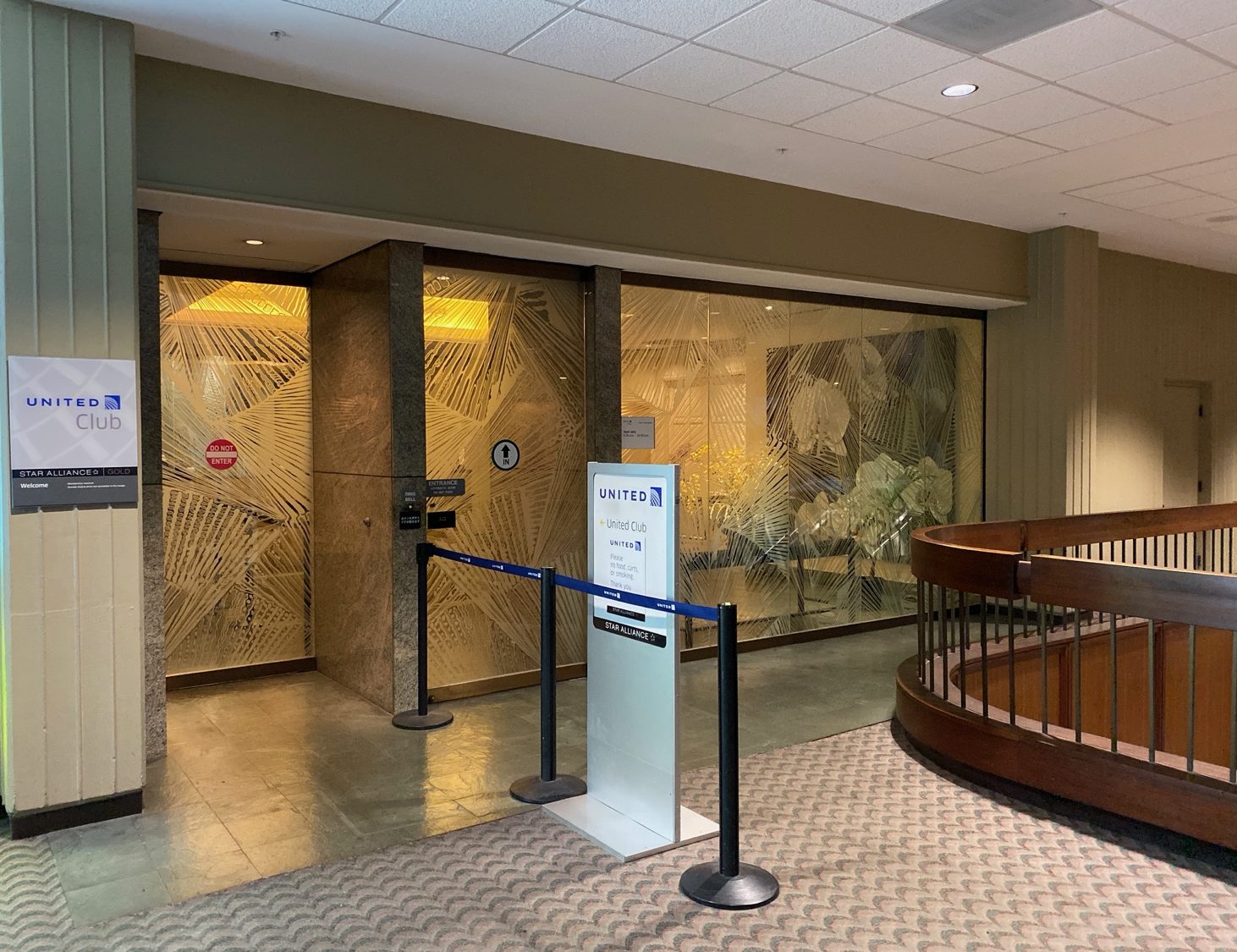 a glass wall with a railing and a sign