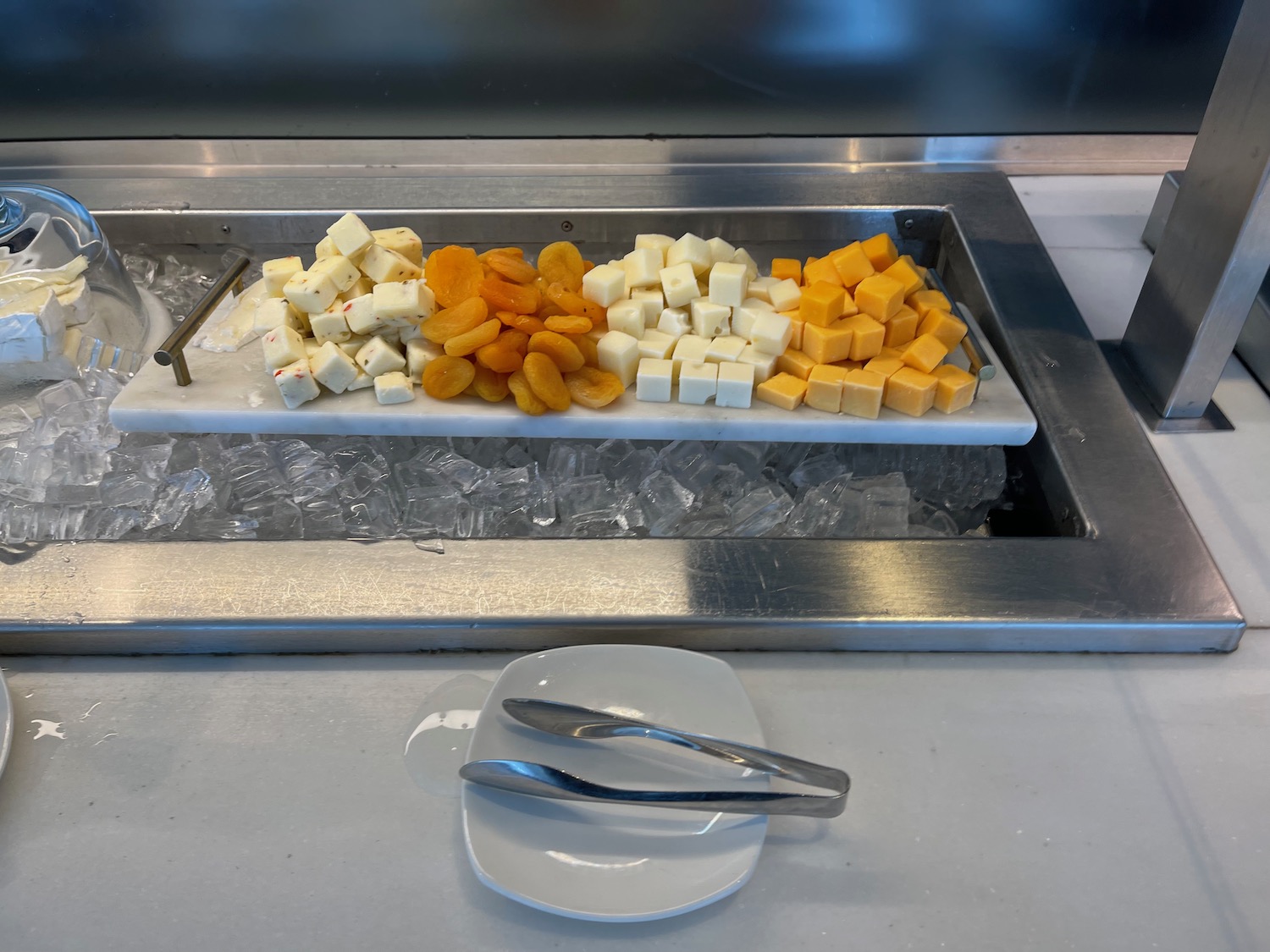 a tray of cheese and apricots on ice