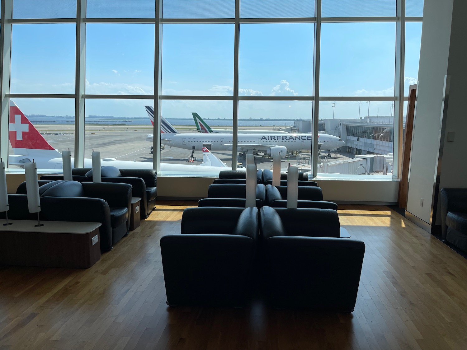 a room with chairs and a large window with planes in the background