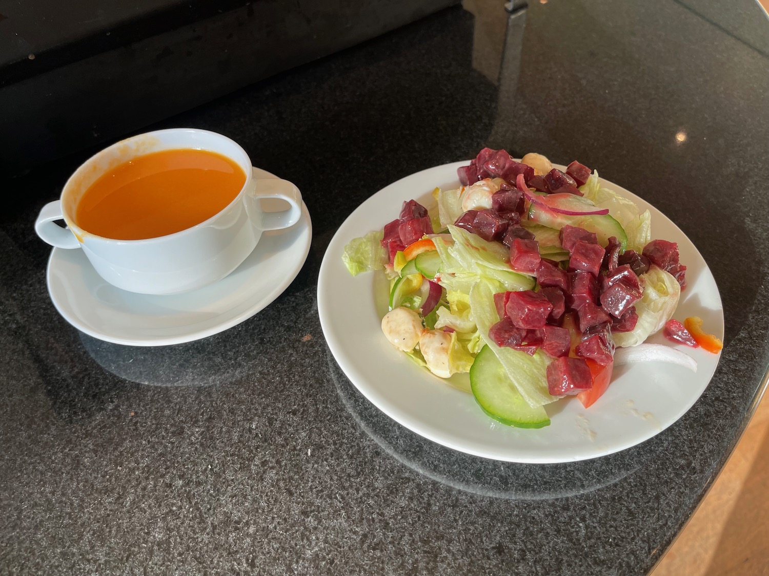 a plate of salad and a cup of orange juice