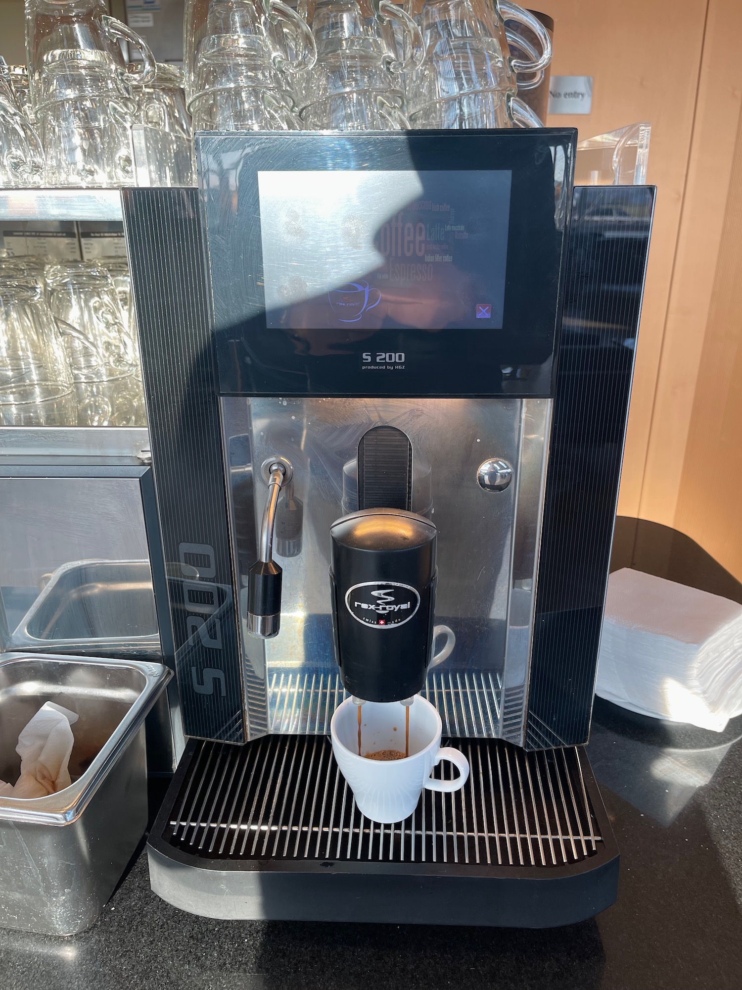 a coffee machine with a screen and a cup of coffee