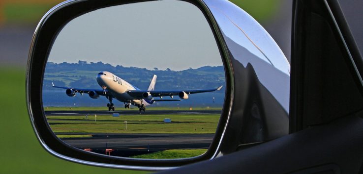 a side view mirror of a plane taking off