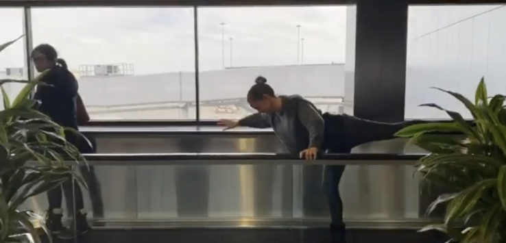 a woman stretching her leg in a room with a window