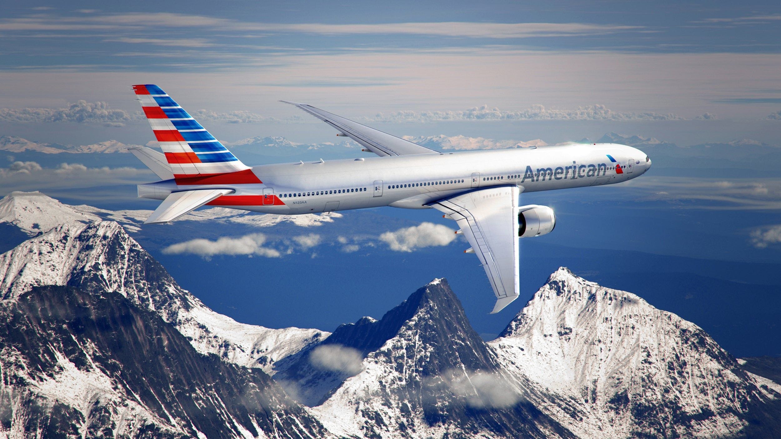 an airplane flying in the sky over mountains