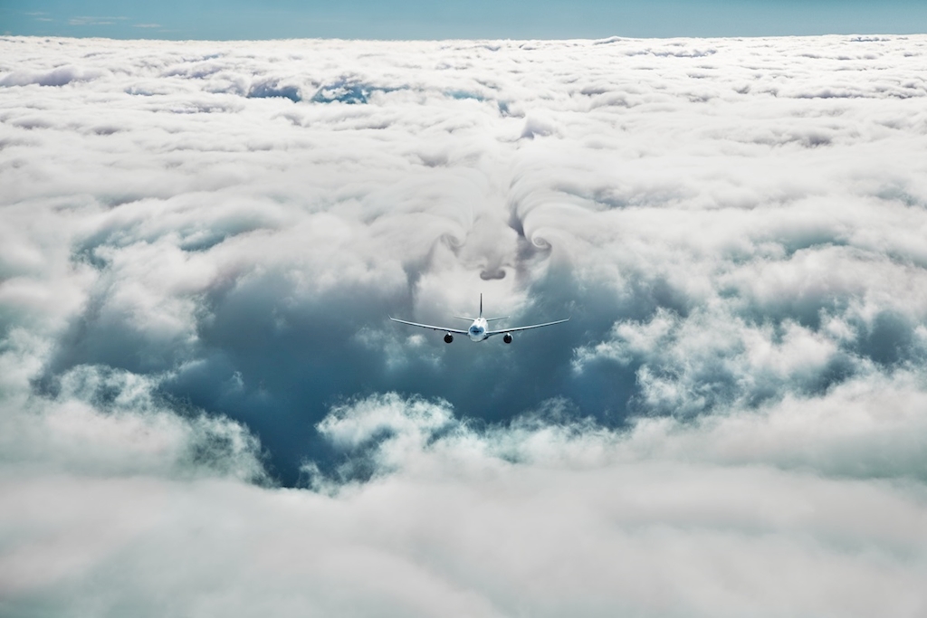 an airplane flying above clouds