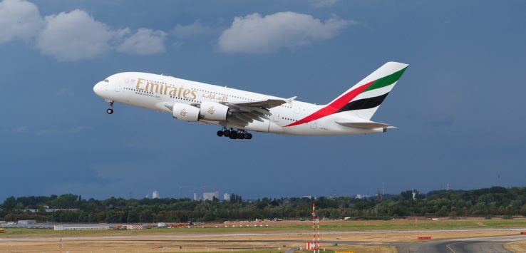 a large airplane flying over a runway