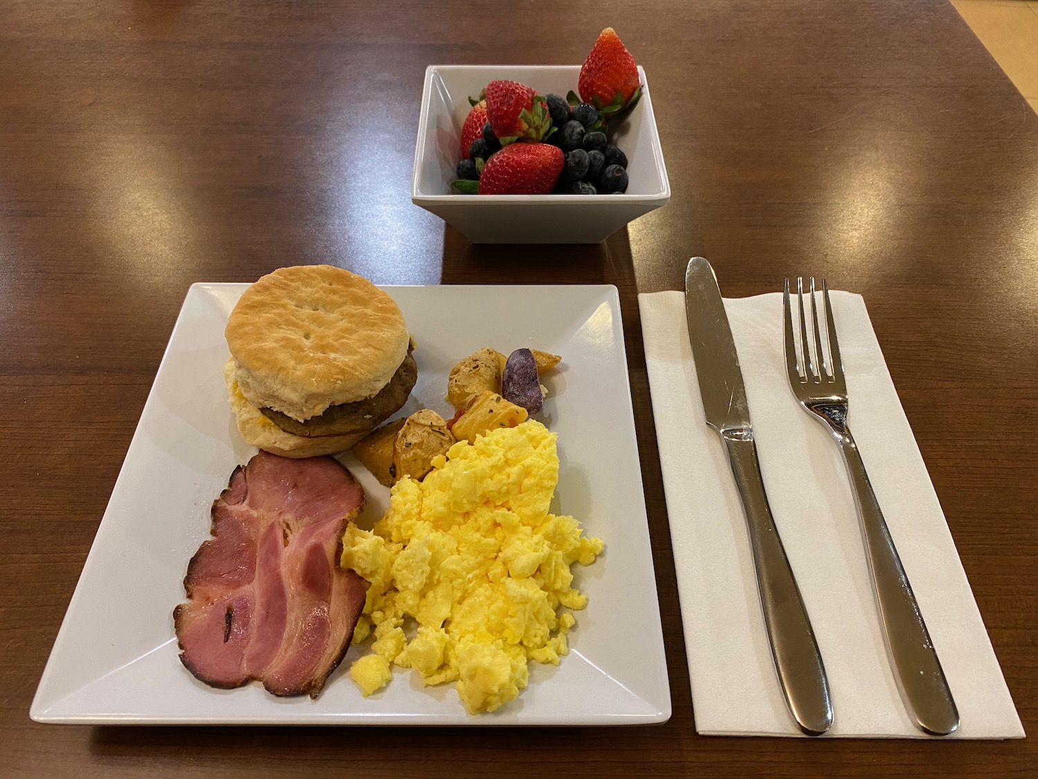 a plate of food and a bowl of strawberries