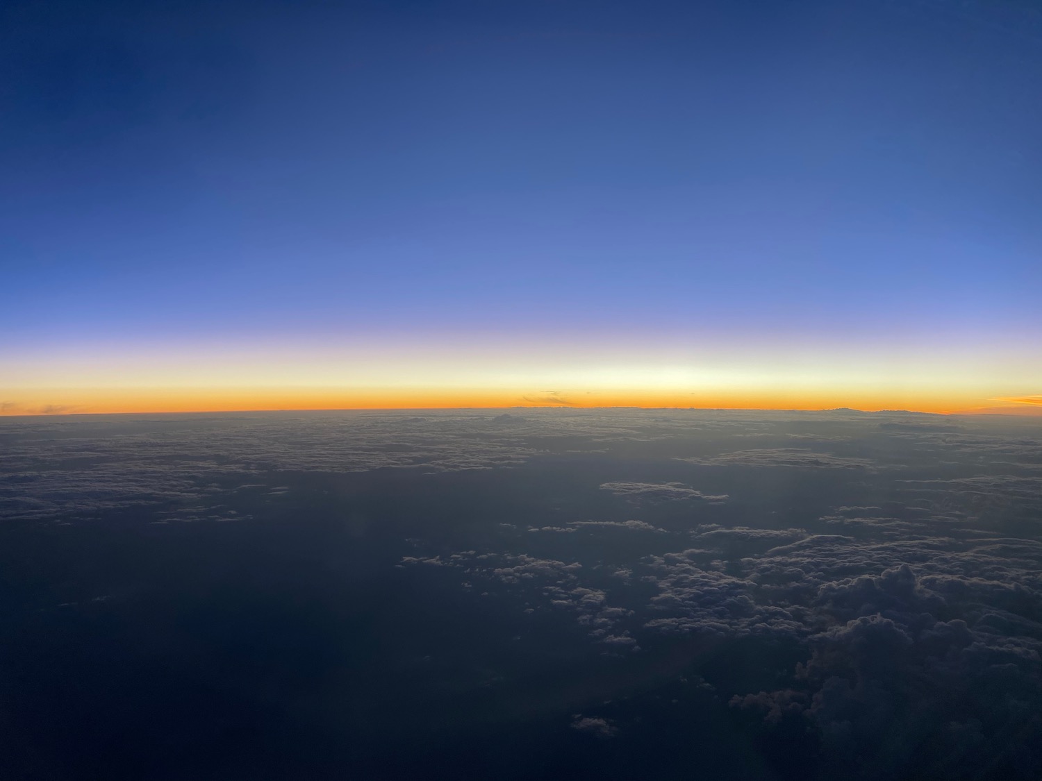 a view of clouds and the sun from an airplane window