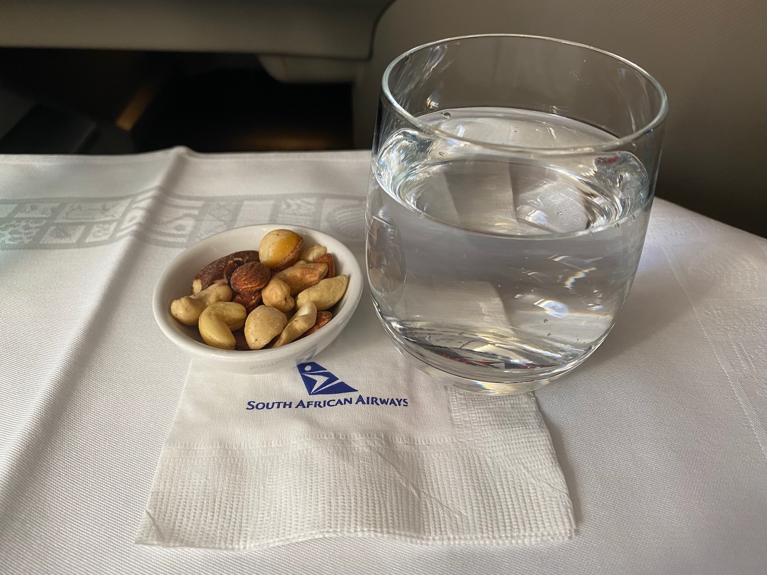 a bowl of nuts and a glass of water