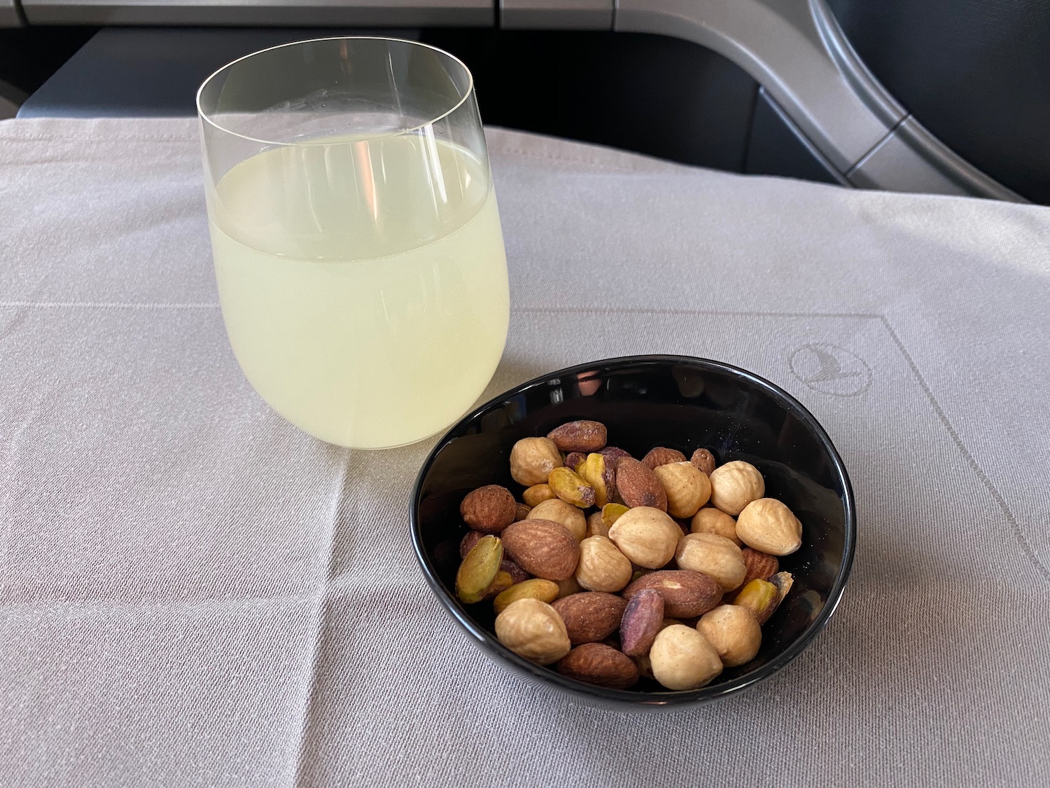 a bowl of nuts and a glass of liquid