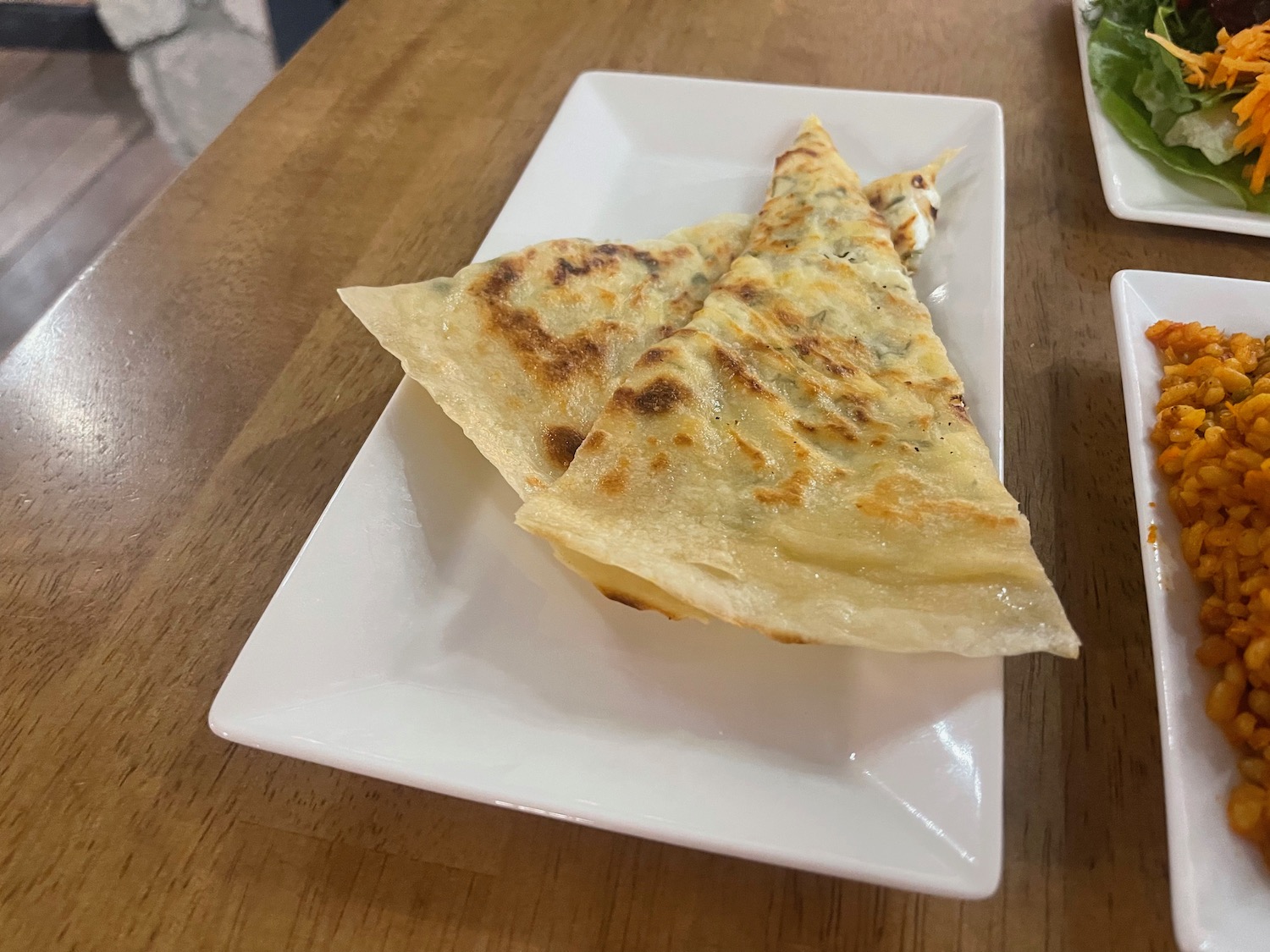 a plate of quesadilla on a wood table