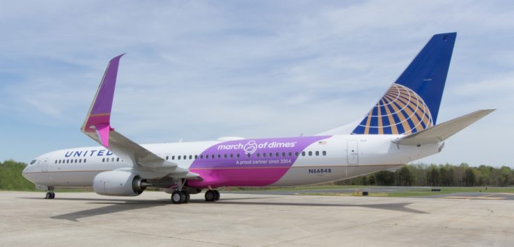 a white and purple airplane on a runway