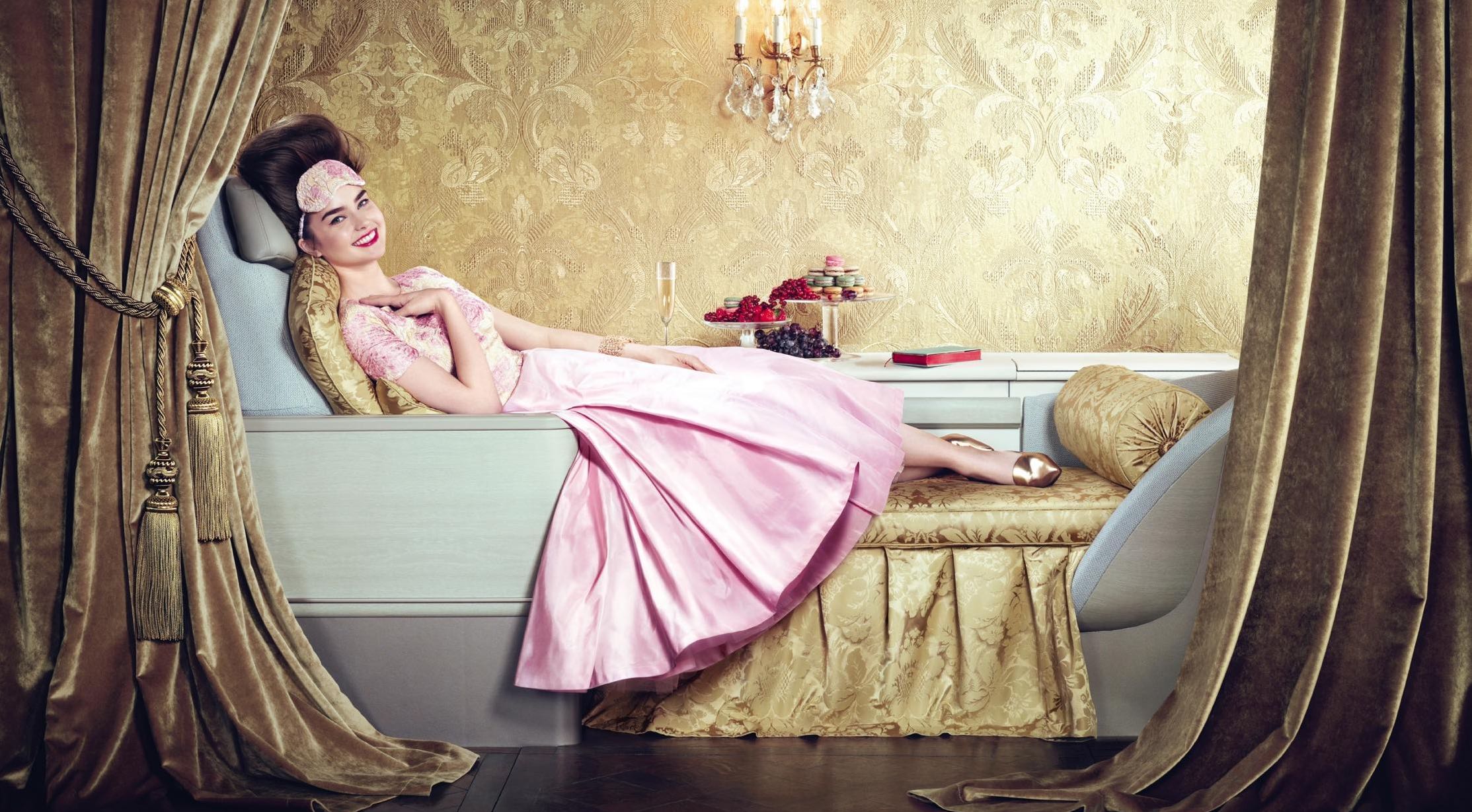 a woman in a pink dress lying on a couch
