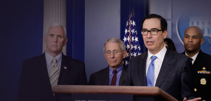 a man in suit and tie standing at a podium with other men in suits